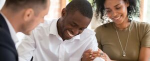 Happy african black family couple customers renters tenants sign mortgage loan investment agreement or rental