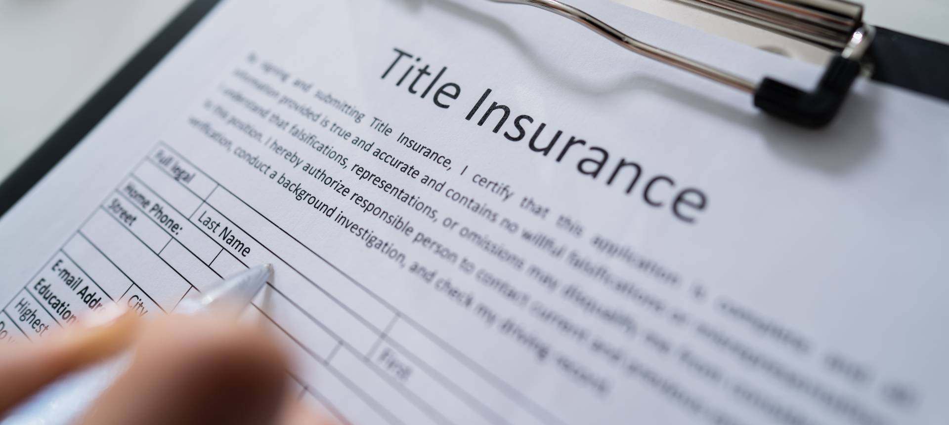 Woman Filling Title Insurance Form Over White Desk