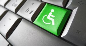 Web content accessibility concept with wheelchair icon and symbol on a green computer key